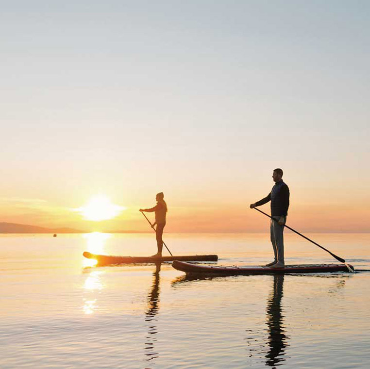 fox and aikins stand up canoing at the beach